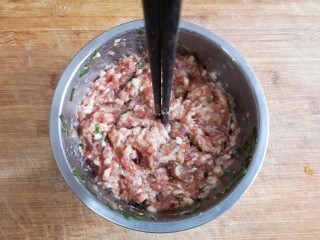 4、玫瑰花蒸饺,用筷子顺着一个方向搅拌肉糜使其上劲,筷子能立在肉糜中。