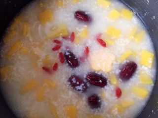 9、小米南瓜红枣粥,待粥浓稠了，差不多时，加入枸杞子，继续熬煮，直至电饭煲自动跳档到保温上即可。