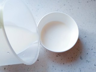 23、午后时光_红枣双皮奶,然后将量杯里的牛奶，顺着碗边缓慢的倒进去，一定要慢，角度也要平缓，不要破坏已经结好的奶皮，倒好后碗口铺上保鲜膜封口