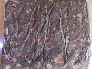 13、枣泥核桃糖,按照枣泥核桃糖的边缘，把烘焙纸折成，方形，用擀面杖把纸包糖团擀平