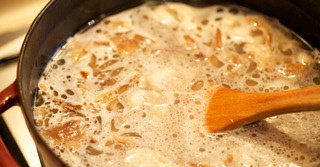 6、猪肉粥,倒入水，放入泡软搓净的野山菌，待浸泡的水沙土沉淀后将清汤也倒入锅中，泥沙留在碗底。放入大米、干贝、盐、白胡椒。上盖小火煮1.5h或至米汤粘滑，中间注意搅拌2-3次