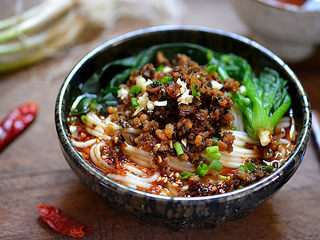 3、担担面,将煮熟的面条和菠菜挑入调料碗中，再舀两勺之前做好的芽菜肉臊子，撒点葱花，吃的时候拌匀就可以了