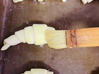 14、牛角酥,全部做完放入烤盘中。表面刷上蛋黄液。