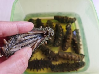 3、小米海参粥,泡软的海参用剪刀纵向剪开腹部，留着海参的筋，把腹腔里的杂物及沙嘴去除，冲洗干净。