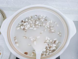 13、香菇腊肉蔬菜粥,大米粒全部都煮开后，而且看上去汤汁不再是水，变得稍微粘稠的时候，加香菇丁。用勺子从下往上地翻动，把汤浇到香菇上面，然后盖上盖子，继续小火煮。