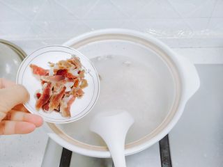 14、香菇腊肉蔬菜粥,粥变得浓稠，并且汤没过粥的时候，下腊肉片，搅动，每一片都搅开。继续小火煮。