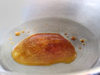 4、排骨面,锅中倒入油放入冰糖，炒出糖色。再放入排骨，让每块排骨包裹上糖色。