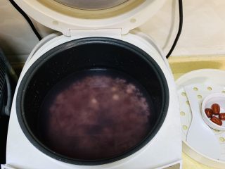 3、夏日冰饮冰镇黄糖八宝粥,泡好后的谷米放进电饭煲，加入大约1300ml-1500ml清水。清水的多少按自己家庭浓稠口味增减。
