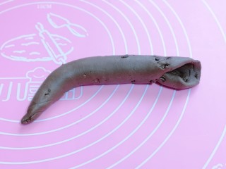 7、懒人必做～巧克力贝果,再卷成长条状，搓成圆柱形，一边尖，一边压扁，如图。