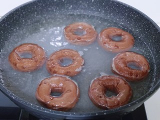 12、懒人必做～巧克力贝果,将醒发好的贝果胚面朝上放入锅中烫30秒，再翻一面烫30秒！（记得哪个先放，哪个后放的哈，时间到立即取出放在油纸上淋干）