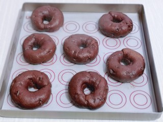 13、懒人必做～巧克力贝果,将贝果放在垫有油纸的烤盘上淋干。