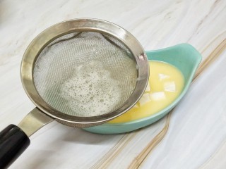 6、猪肉豆腐鸡蛋羹,将其过筛的倒入到放有豆腐的容器中