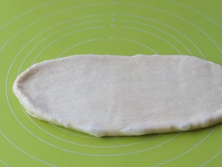 15、米粥吐司,取一块松弛好的面团，按扁，擀开成牛舌状