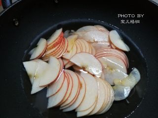 2、苹果玫瑰卷,锅里放入清水，白砂糖，熬开后。放入苹果片，煮一分钟就捞起来