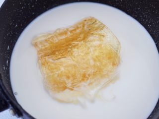 5、酸奶草莓冻,加入吉利丁片，吉利丁片要挤干水份再加入，小火加热，边煮边搅拌至吉利丁片融化