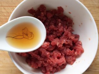 5、板栗牛肉粥～,加入半勺料酒，拌匀腌制十分钟至其入味。