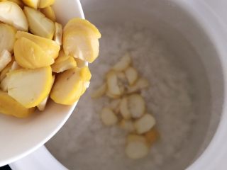 13、板栗牛肉粥～,将切好的板栗肉也倒入锅中，搅匀，盖上盖儿大火烧开转小火慢煲。