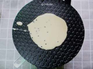 7、香酥蛋卷,我用的是燃气灶的蛋卷锅，小火提前预热锅，。预热好的锅内用勺子舀上一勺面糊。也可以用不粘平底锅