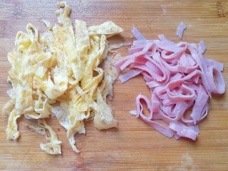 5、火腿鸡蛋炒面,然后把鸡蛋皮也切成细丝；