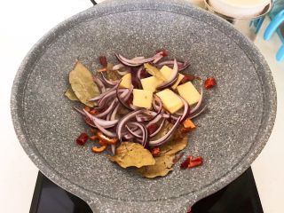 6、家常红烧牛腩面,加入葱丝和姜片,炒出香味