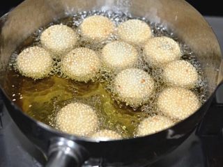 12、老街煎堆,按瘪的麻球会再次鼓起来，重复按压的动作3～4次至麻球浮起圆鼓鼓的呈现金黄色即可