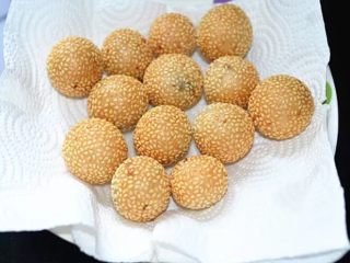 13、老街煎堆,捞出的麻球放在厨房纸上吸取表面多余的油脂，稍凉一点就可以吃了