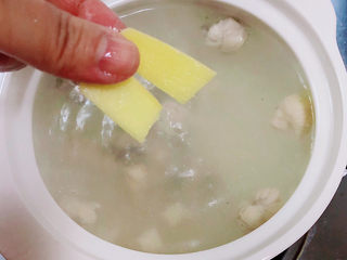 8、鸡肉山药粥,撇弃表层的鸡油，放入姜片，盖盖儿小火炖煮10分钟。