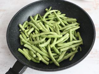 5、酱香干煸豆角,放入豆角,不停煸炒。