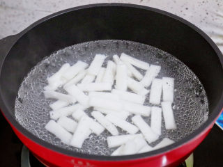 4、香辣孜然火腿肠炒年糕,锅中注入清水，烧开后放入年糕，煮3-5分钟，煮至年糕变软捞出控干水分备用