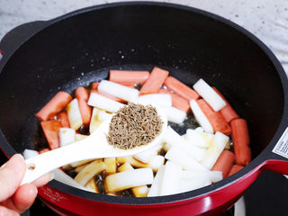 8、香辣孜然火腿肠炒年糕,加入孜然粒