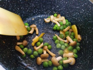 8、超级鲜美的海鲜粥,炒出虾油，把虾头挑出来，放蟹味菇和青豆，炒至断生