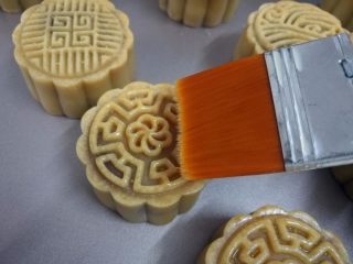 16、广式蛋黄月饼,取少许鸡蛋黄加少许水稀释后，用毛刷在月饼上薄薄刷上一层蛋液。