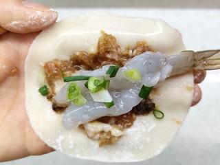 4、猪肉大虾煎饺,饺子皮先放肉馅，再放一个虾仁，再撒上葱花，中间包起来，留出二头。