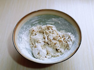 2、皮薄馅大～发面梅干菜肉饼,先发酵面，面粉中加入酵母粉，分次加入温水，搅成絮状。