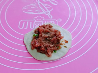 13、皮薄馅大～发面梅干菜肉饼,取一块面团，用擀面杖擀圆饼，放上拌好的馅。
