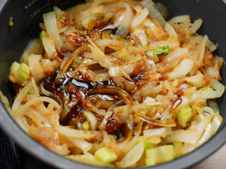 11、电饭煲红酒烩牛尾,把炒锅的菜倒入电饭煲，加入2勺生抽。