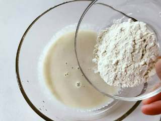 3、宝宝辅食：苹果栗子饼,倒入面粉，用手动打蛋器或筷子搅拌均匀，直至细腻看不到面块。