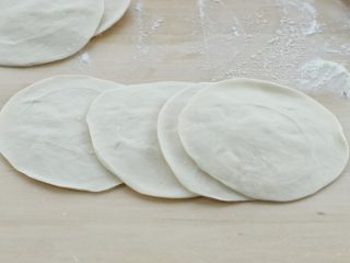 6、烫面豆沙饼,再用擀面杖擀成中间厚些边缘稍薄的饼皮，不操作的面团用保鲜膜盖上，防止风干