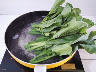 5、白灼芥兰,锅里的水烧开后放入15克猪油，2克盐，先放芥兰的根部灼水