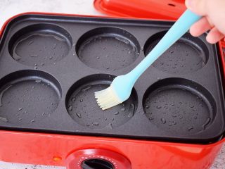 14、煎薄罉,美食锅放入6圆孔多用途烤盘，调节至中温，预热电热锅4分钟后刷一层油