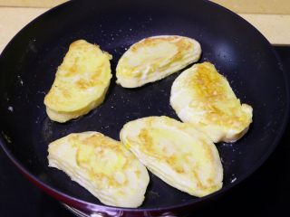 5、蛋煎馒头片,煎至一面金黄后，翻至另一面继续煎