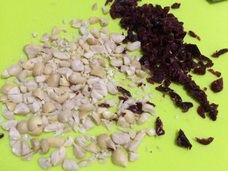 2、牛轧糖夹心苏打饼干,把蔓越莓干和花生切碎些。