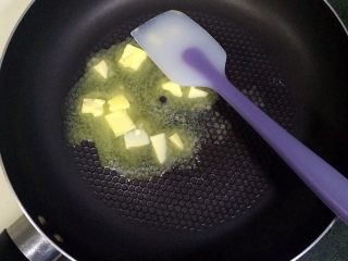 3、牛轧糖夹心苏打饼干,开小火，把黄油倒入不粘锅内。