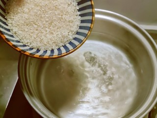 2、蔬菜虾仁粥,汤锅水烧开  放入大米开始煮粥