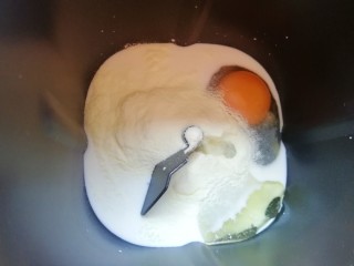 1、甜味面包卷,面包机桶内先倒入牛奶,接下来打入鸡蛋,然后依次加入细砂糖和盐(糖和盐对角放),加入奶粉,加入玉米油。