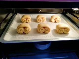 12、甜味面包卷, 烤箱调至“发酵”功能,放入一碗热水,将面包卷送入烤箱二次发酵。