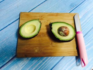 2、香蕉牛油果奶昔,用水果刀对切牛油果，然后沿着果核轻轻转动一圈，再用双手分别抓住一半，拧转一下就可以打开啦