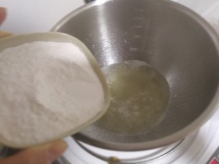 5、中式点心+老婆饼,把装好材料的盆放在电磁炉上。先大火烧开,然后改小火。快速的倒入糯米粉。