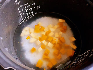 10、红薯南瓜粥,把南瓜块和红薯块都放进泡好的米中。