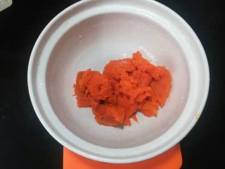 2、脆皮南瓜饼,趁热刮到大一点的容器里。